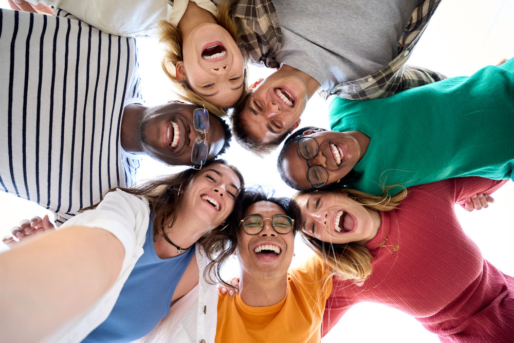 group of people standing in a circle, smiling, looking down at camera